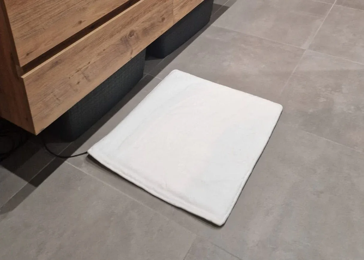 Witte verwarmde badmat in een moderne badkamer